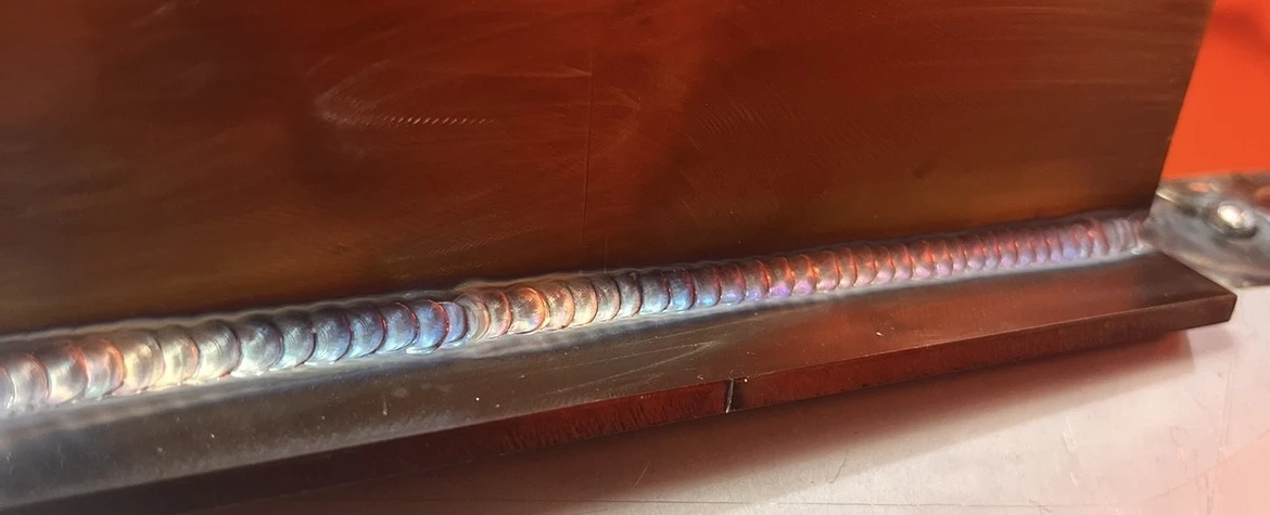 Close-up of a long weld with distinct ripples and heat tint